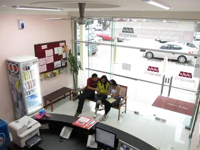 two people sitting on a bench in a store at Broadway Budget Hotel in George Town