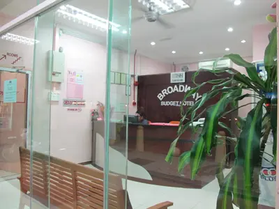 a store with a sign on the wall and a plant at Broadway Budget Hotel in George Town