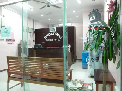 a restaurant with a bench and a sign in a store at Broadway Budget Hotel in George Town