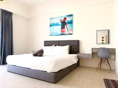 a bedroom with a bed and a painting on the wall at By The Sea Suites - Managed by SDBMS in Batu Ferringhi