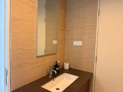 a bathroom with a sink and a mirror at By The Sea Suites - Managed by SDBMS in Batu Ferringhi
