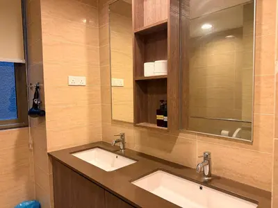a bathroom with two sinks and a mirror at By The Sea Suites - Managed by SDBMS in Batu Ferringhi