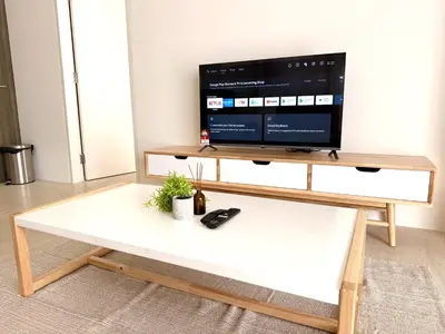 a coffee table with a tv on top of it at By The Sea Suites - Managed by SDBMS in Batu Ferringhi