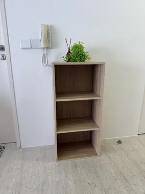 a wooden book shelf with a plant on it at By The Sea Suites - Managed by SDBMS in Batu Ferringhi