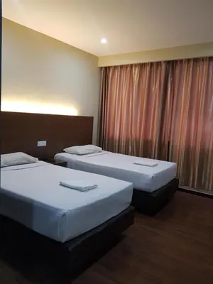 a hotel room with two beds and a window at Garden Inn, Penang in George Town