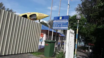 a street sign next to a fence and a trash can at Penang Tg Bungah Permai Ria Apartment in Tanjung Bungah