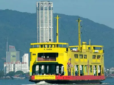 a yellow boat in the water with buildings in the background at Penang Tg Bungah Permai Ria Apartment in Tanjung Bungah