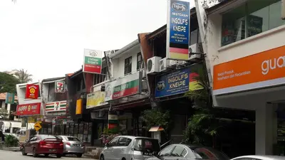 a city street with cars parked in front of buildings at Penang Tg Bungah Permai Ria Apartment in Tanjung Bungah