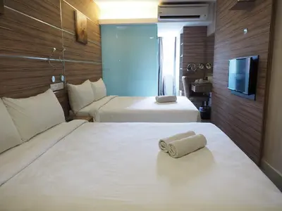 a hotel room with two beds and a flat screen tv at Mornington Hotel Medan Ipoh in Ipoh