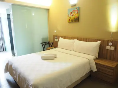 a bedroom with a large bed with white sheets at Mornington Hotel Medan Ipoh in Ipoh