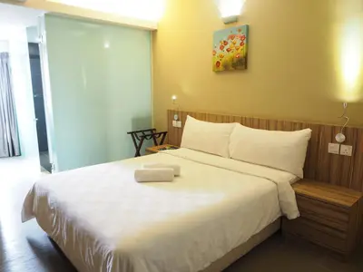 a bedroom with a large bed with white sheets at Mornington Hotel Medan Ipoh in Ipoh