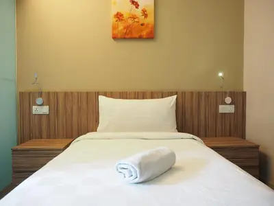 a bed with a towel laying on top of it at Mornington Hotel Medan Ipoh in Ipoh