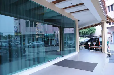 a glass facade of a building with parked cars at Marina Oriental Hotel in Butterworth