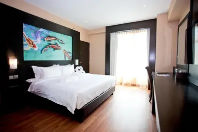 a bedroom with a large white bed and a large window at Vouk Hotel Suites, Penang in George Town