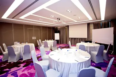 a conference room with white tables and chairs and a whiteboard at Vouk Hotel Suites, Penang in George Town