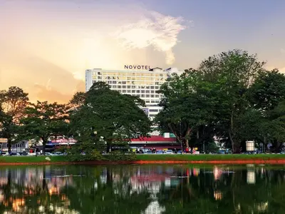 a hotel in a city with a reflection in the water at Novotel Taiping in Taiping