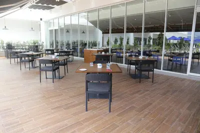 a restaurant with wooden tables and chairs and windows at Novotel Taiping in Taiping