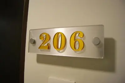 a sign on a door with the number on it at Double Happiness Hotel in Seri Manjung