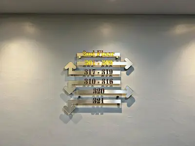 a sign hanging on a wall with arrows on it at Double Happiness Hotel in Seri Manjung
