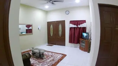 a living room with a door and a television at Homestay selinsing in Simpang Ampat Semanggol