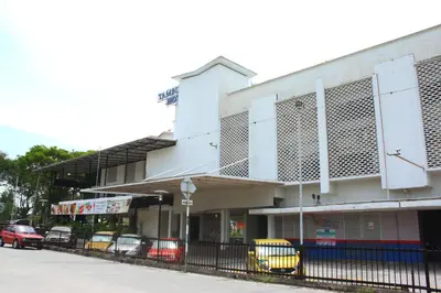 a white building with cars parked in front of it at Tambun Inn Hotel in Ipoh