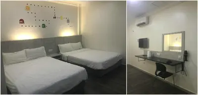 a hotel room with two beds and a desk at Tambun Inn Hotel in Ipoh