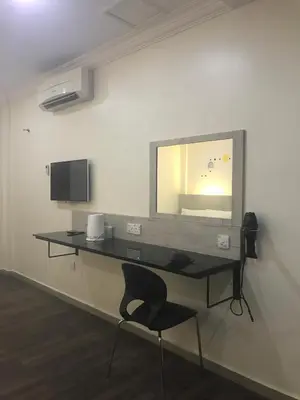 a desk in a room with a chair and a mirror at Tambun Inn Hotel in Ipoh