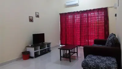 a living room with a red curtain and a television at Taiping Valuable Homestay in Taiping