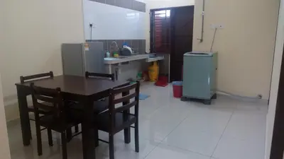 a kitchen with a table and chairs and a refrigerator at Taiping Valuable Homestay in Taiping
