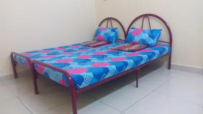 a bed with two pillows on it in a room at Taiping Valuable Homestay in Taiping