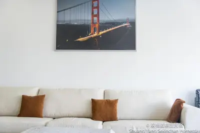 a white couch with a picture of the golden gate bridge at Shuang Yang Sekinchan Homestay in Sekincan