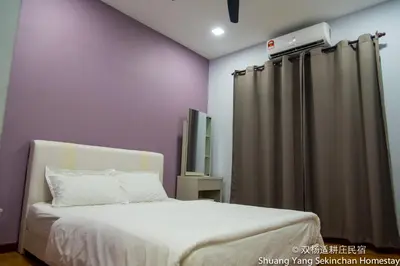 a bedroom with a bed and a curtain at Shuang Yang Sekinchan Homestay in Sekincan