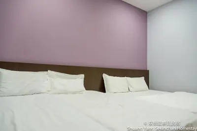a large bed with white sheets and pillows at Shuang Yang Sekinchan Homestay in Sekincan