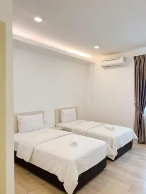 two beds in a room with white walls at Vvip Hotel in Hutan Melintang