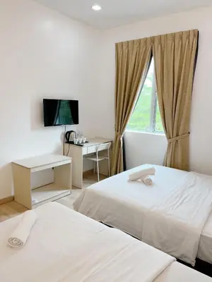 a hotel room with two beds and a window at Vvip Hotel in Hutan Melintang
