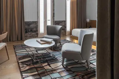 a hotel room with a bed and two chairs and a table at Macalister Mansion, a Member of Design Hotels in George Town