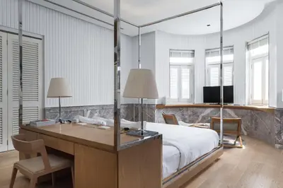 a bedroom with a bed and a desk with two lamps at Macalister Mansion, a Member of Design Hotels in George Town