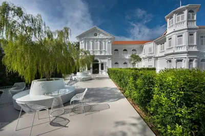 a large white mansion with a table and chairs at Macalister Mansion, a Member of Design Hotels in George Town