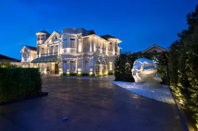 a white mansion with a statue in front of it at Macalister Mansion, a Member of Design Hotels in George Town