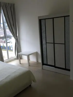 a bedroom with a bed and a table next to a window at Cameron New Apartment @ Golden Hill in Cameron Highlands