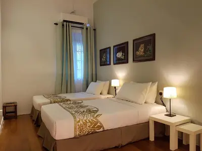 two beds in a room with two lamps and a window at MY CHINAMAN'S HOME II in George Town