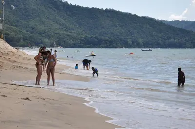 a group of people standing on a beach at Aloka Seaview Apartment in Batu Ferringhi