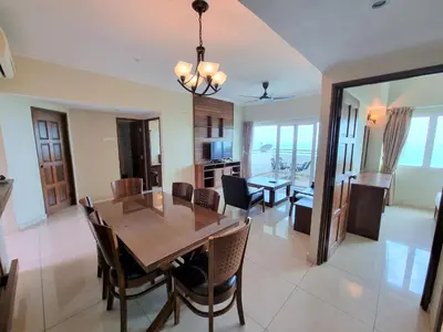 a dining room and kitchen with a table and chairs at Aloka Seaview Apartment in Batu Ferringhi