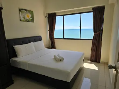a bedroom with a bed with a large window at Aloka Seaview Apartment in Batu Ferringhi