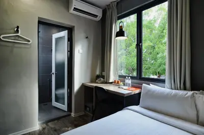 a bedroom with a bed and a sink and a window at Chariton Hotel Alma in Bukit Mertajam
