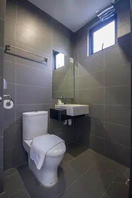 a bathroom with a toilet and a sink at Chariton Hotel Alma in Bukit Mertajam