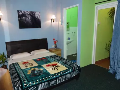 a bedroom with a bed and a bathroom with a sink at Orchid Haven in Cameron Highlands