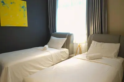 two beds in a room with a window at The Majestic Ipoh by The Osborne in Ipoh
