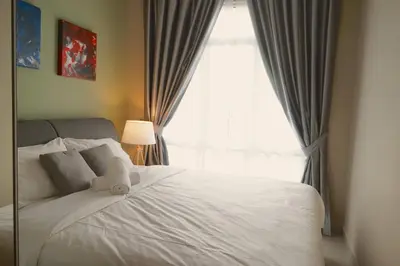 a bedroom with a large white bed with a window at The Majestic Ipoh by The Osborne in Ipoh