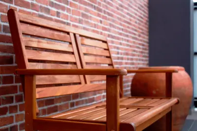 a wooden bench sitting next to a brick wall at Austin GuestHouse in Ipoh